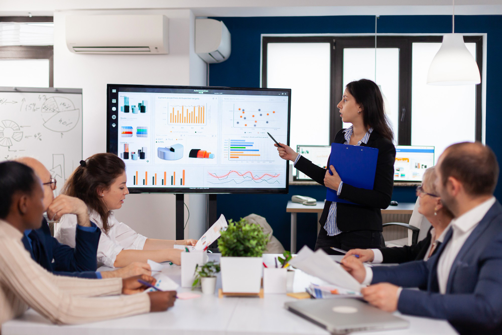 Lady presenting and pointing to diagrams on a television