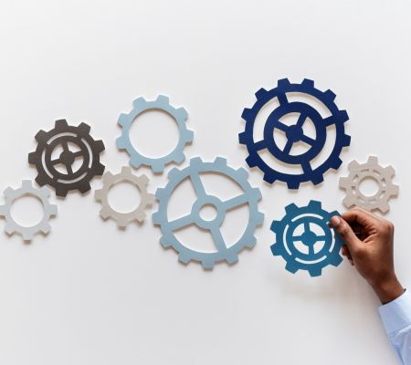 Different size blue and grey cogs stuck to a wall
